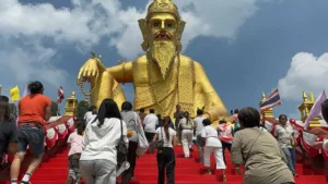 ประชาชนจำนวนมากเดินขึ้นบันไดสีแดงเพื่อไปกราบสักการะองค์ปู่ฤๅษีพรหมเมศองค์ใหญ่สีทอง ณ อาศรมฤๅษีเณร